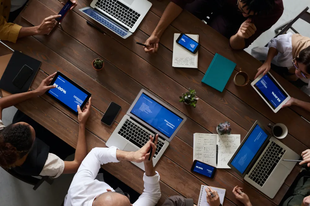 6 people in a meeting with gadgets on the table
