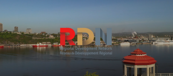 Regional Development Network logo, against a region, with water source, boats on the water, and buildings close to the shore