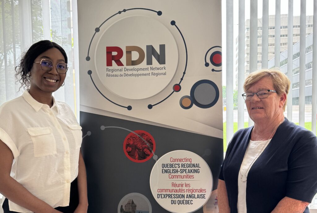 The executive director of RDN and RDN's summer communications associate pose with the RDN banner.